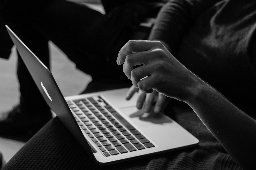 Graustufenfoto einer Person, die ein MacBook verwendet