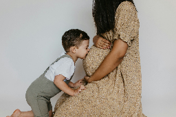 eine Frau, die einen Babyjungen hält und ihn küsst